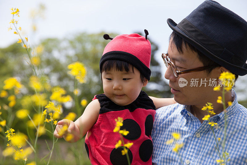 年轻的父亲和他可爱的女儿穿着瓢虫装