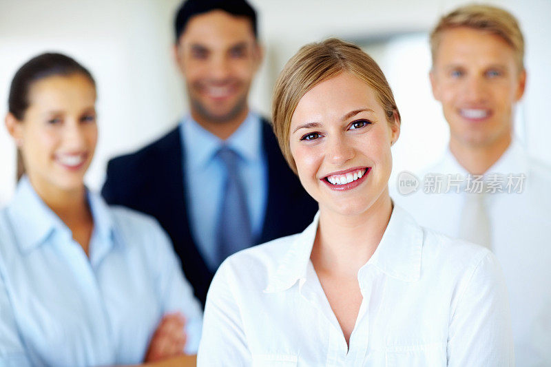 女商务女性在照相机与同事微笑