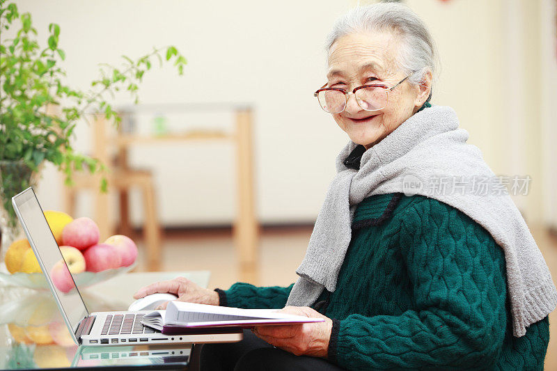 一名资深亚洲女性使用笔记本电脑的照片