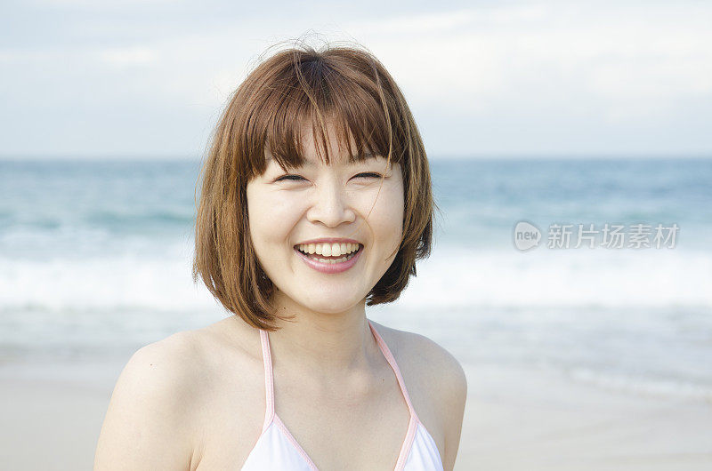年轻女子在海边，微笑着，画像