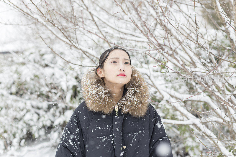 一个美丽的亚洲女人站在雪地里的肖像