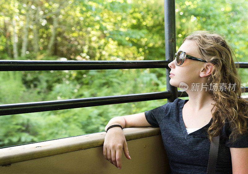 孤独的女孩坐火车经过绿树