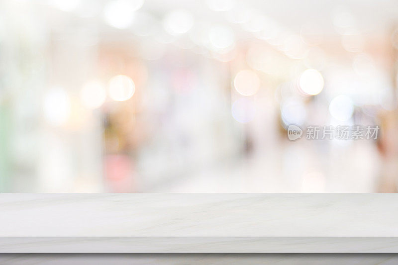 空白的白色大理石桌子上模糊的商店背景，产品显示蒙太奇