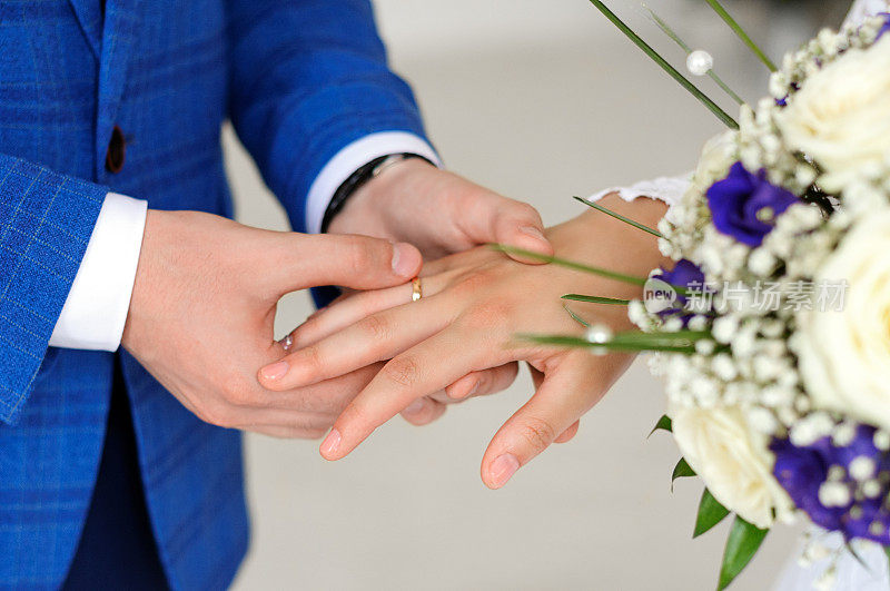 新娘和新郎的手。戴戒指。
结婚的那一天。