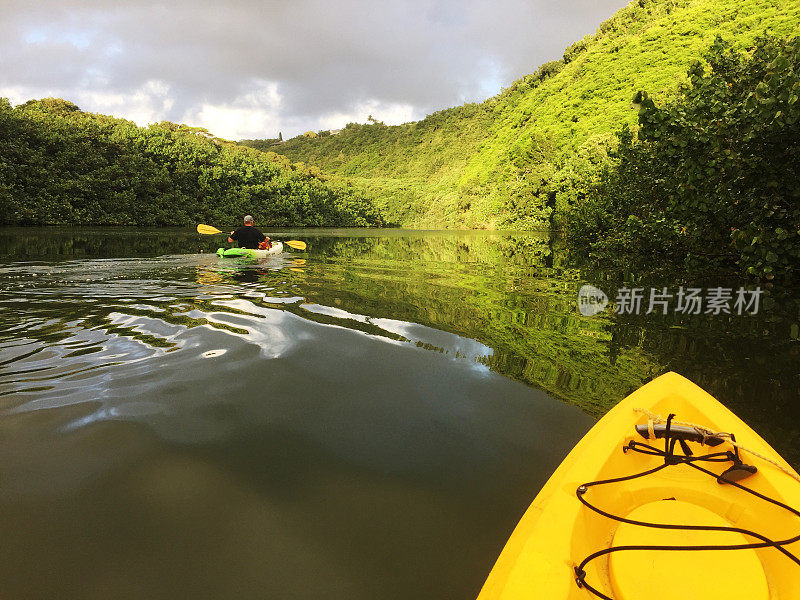 清晨的阳光沐浴在天空中，人们在外陆河上划着皮艇