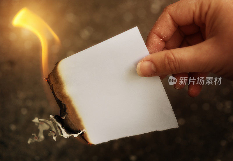 手里拿着一张燃烧着的空白纸