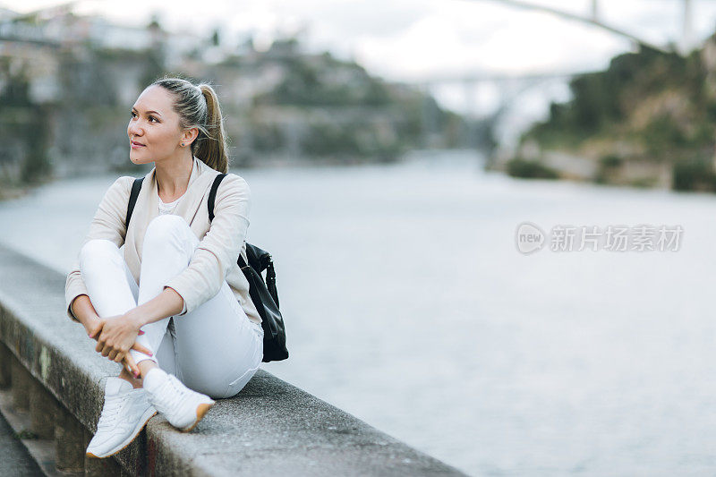 年轻女子背着背包走在欧洲的街道上