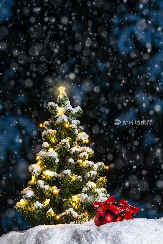 下雪的夜晚，外面挂满彩灯和装饰物的小圣诞树