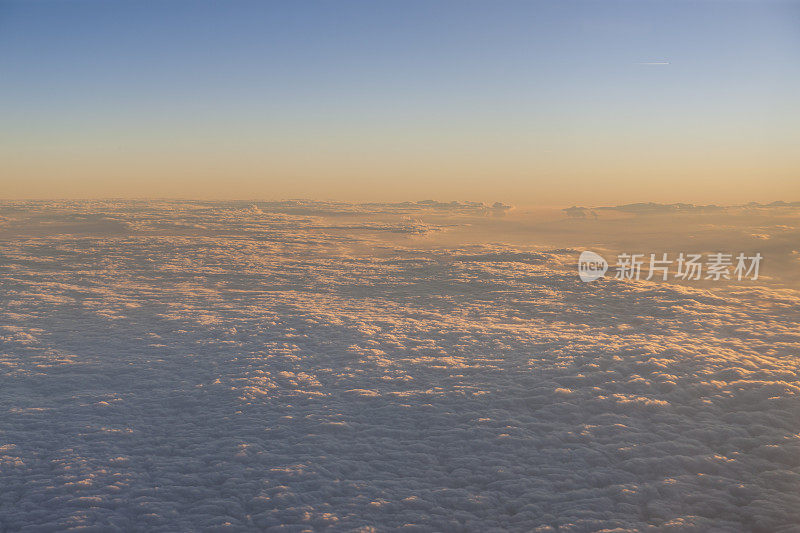 在日落时飞过云层。从飞机窗口观看