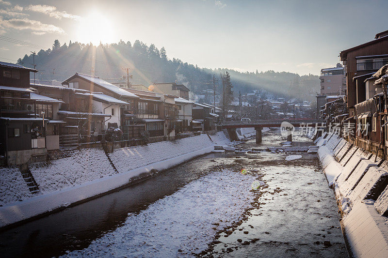 雪山村日出与红色木桥和小溪，日本