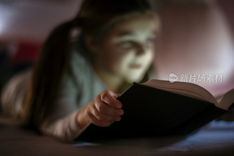 小女孩在床上看书