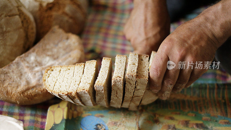 男子切美味新鲜的全麦面包