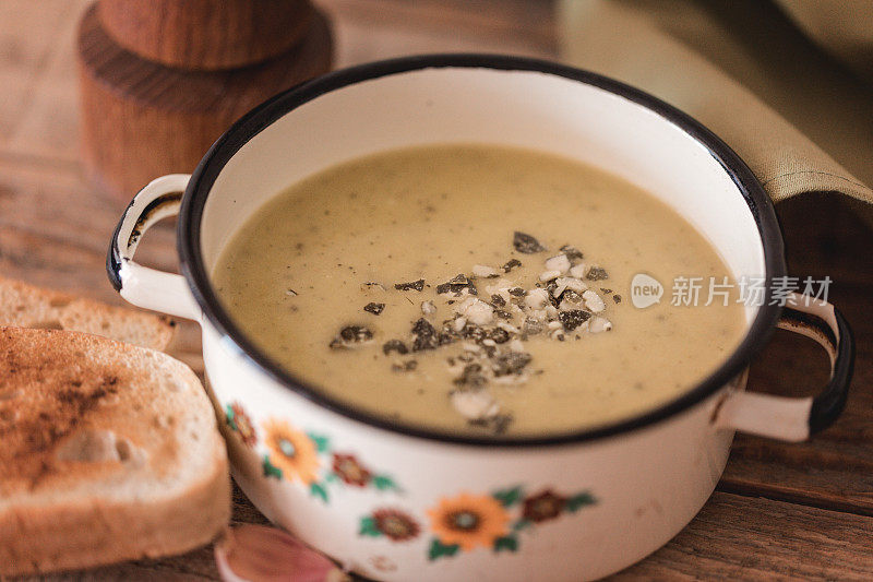 花椰菜汤配南瓜子和烤面包，装在金属盘里即食