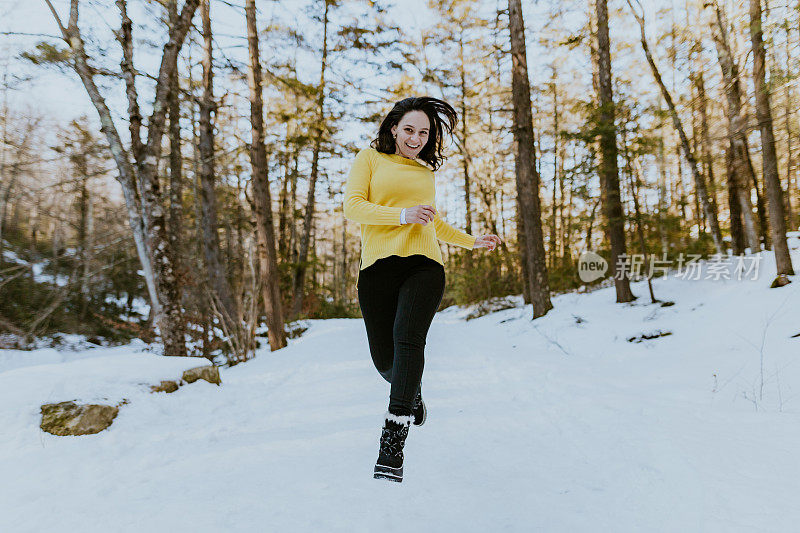 女人在雪地上蹦蹦跳跳