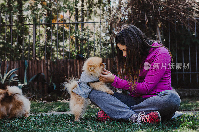 微笑的年轻女子和她的博美犬