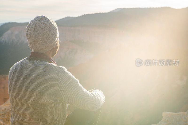 一名年轻人在美国犹他州的布莱斯峡谷国家公园旅行，人们在旅行中探索自然。年轻人在红色的岩层中徒步旅行