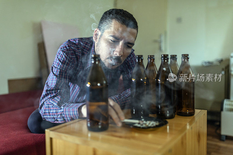 年轻悲伤的醉酒男子喝啤酒和酒精感到浪费，孤独和绝望的痛苦和情绪压力。人与酗酒、上瘾和男人抑郁的概念。