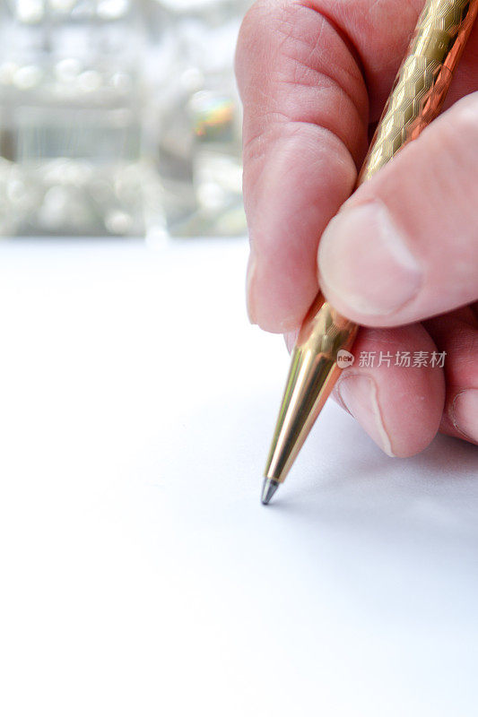 男人用笔在纸上写字，手握笔在纸上写字