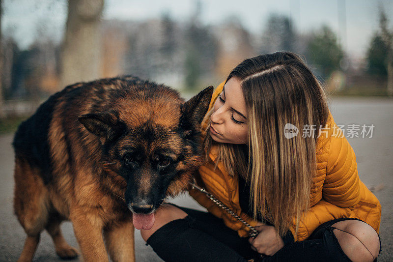 年轻女子和德国牧羊犬在公园里玩