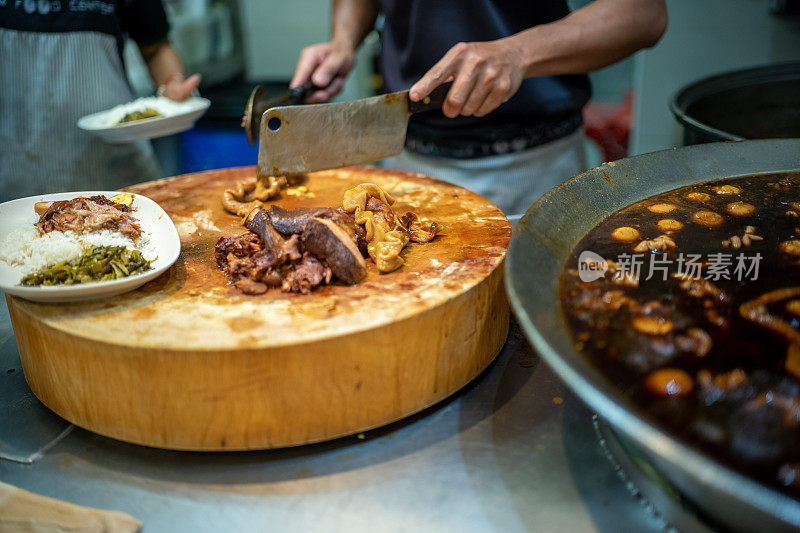 街头小贩正在准备泰式炖猪腿饭