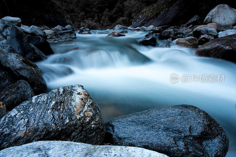 高山溪流在崎岖的环境中流过绿色的岩石