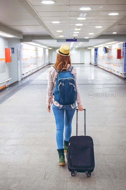 一位年轻女子带着一个手提箱去旅行