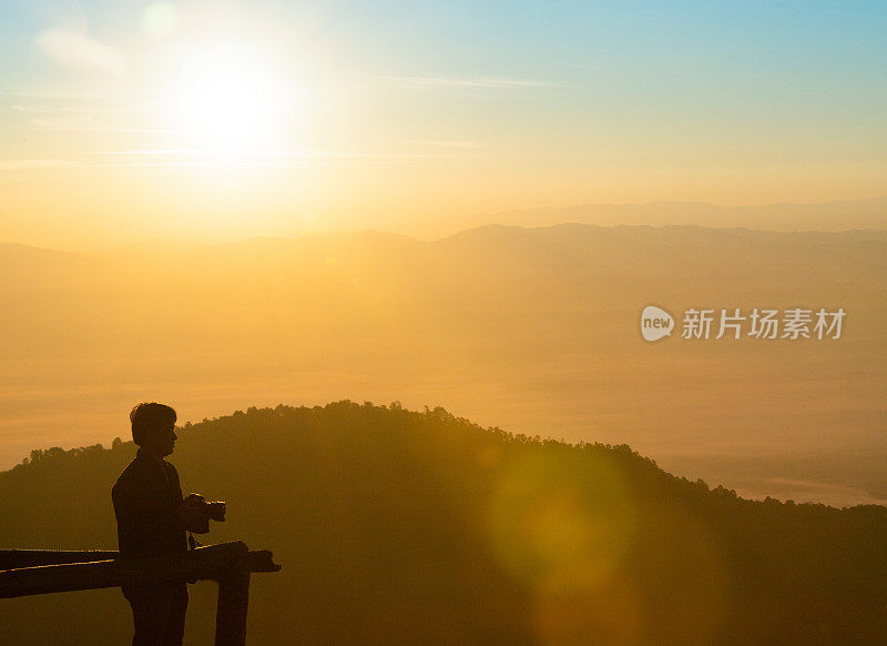 一名年轻人在泰国北部的吴康清迈自然景观日出景区用相机拍照