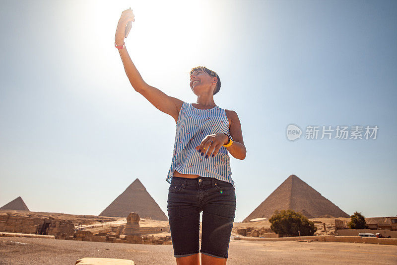 一名成年女子在吉萨金字塔前自拍