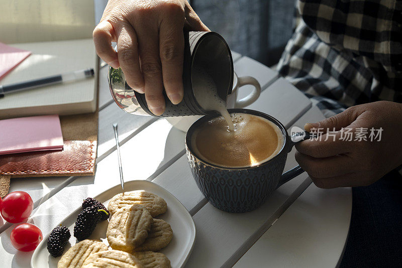 咖啡休息时间:把牛奶倒进浓咖啡里，制成一杯拿铁咖啡