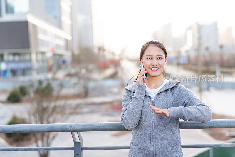 亚洲年轻女子在城市公共广场使用手机