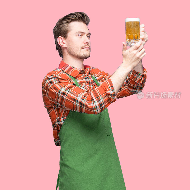 酿酒师-白人体力劳动者站在有色背景前，穿着衬衫，拿着啤酒-酒精