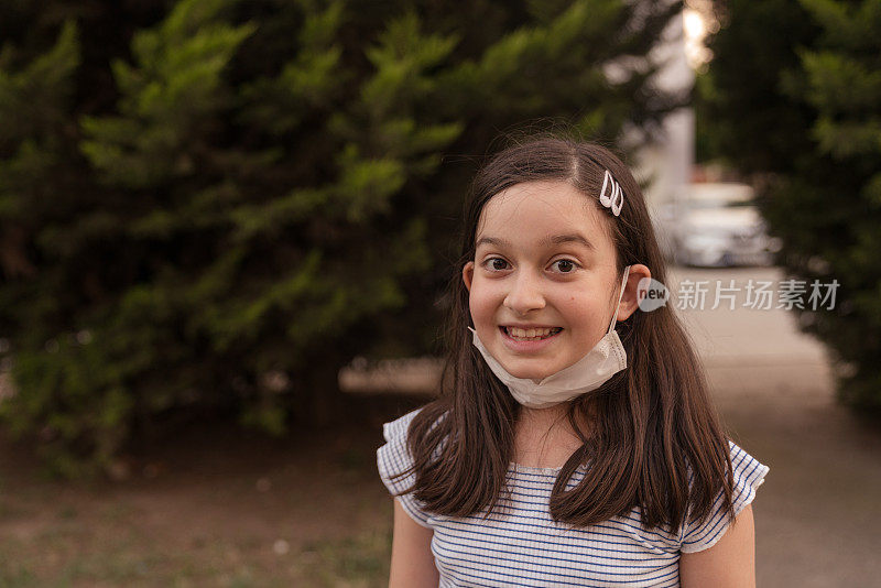 小女孩戴着N95面罩走在街上