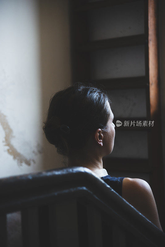 在一所老房子里，一个女人走上楼梯