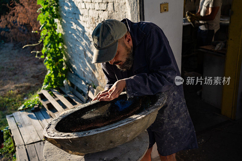 特写的一个人把金粉在他的车间前刚做的水槽作为最后的触摸