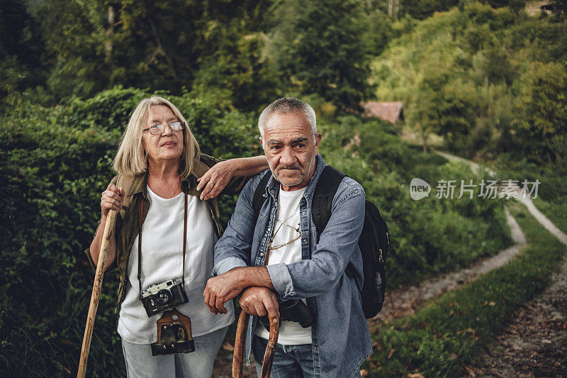 一对老夫妇在大自然中散步——一对快乐的老夫妇在美丽的健康之路上享受他们的假期