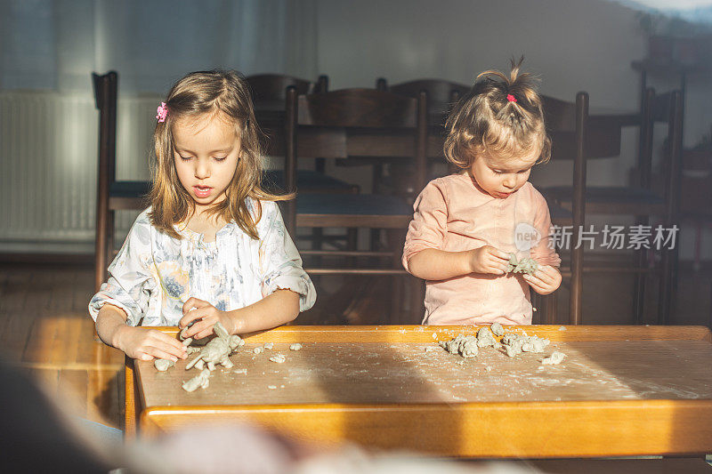 两个女孩在客厅里玩，窗外的景色