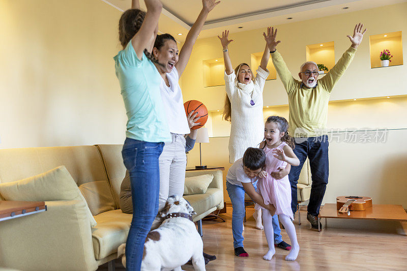 幸福的家庭成员在一起看篮球比赛度过美好的时光。