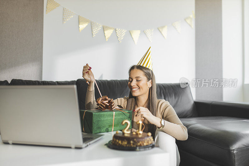 女孩打开礼物，和朋友视频通话庆祝她的21岁生日