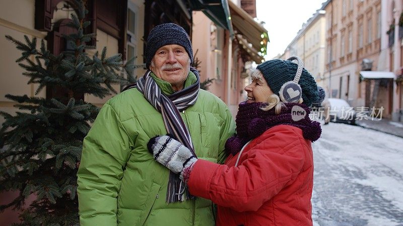 老两口的奶奶爷爷穿着冬衣在城里散步、聊天