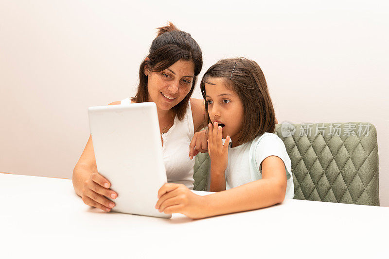 母亲和孩子用平板电脑做作业