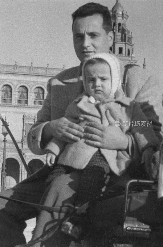 60年代的经典画面，年轻男子和他蹒跚学步的儿子坐在马车里