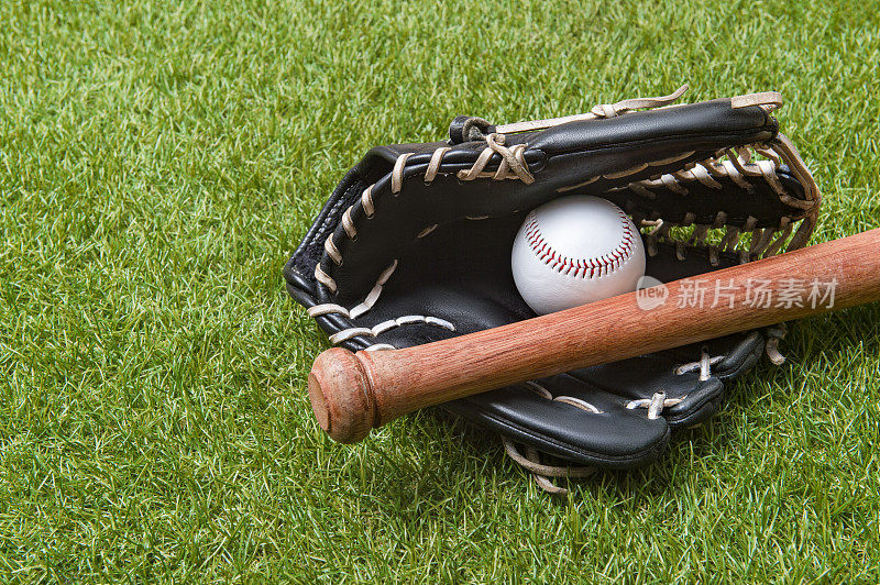草地上的棒球棒、手套和球。体育主题背景与复制空间的文字和广告