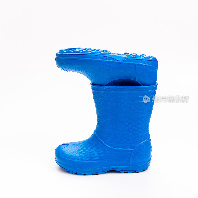 白色背景下的蓝色胶靴。雨天和水坑里穿的鞋子。
