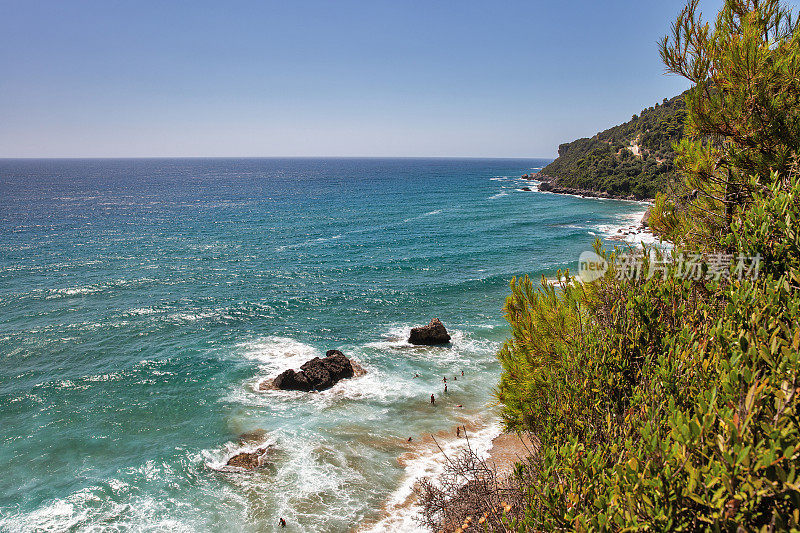 海浪拍打着岩石，溅起水花。科孚岛,希腊。