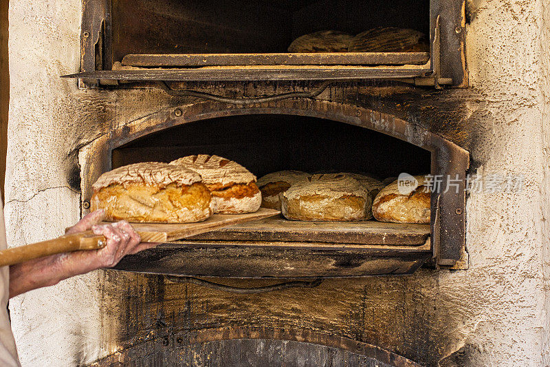 在一个古老的石炭炉里烤面包，传统的奥地利街头炉。