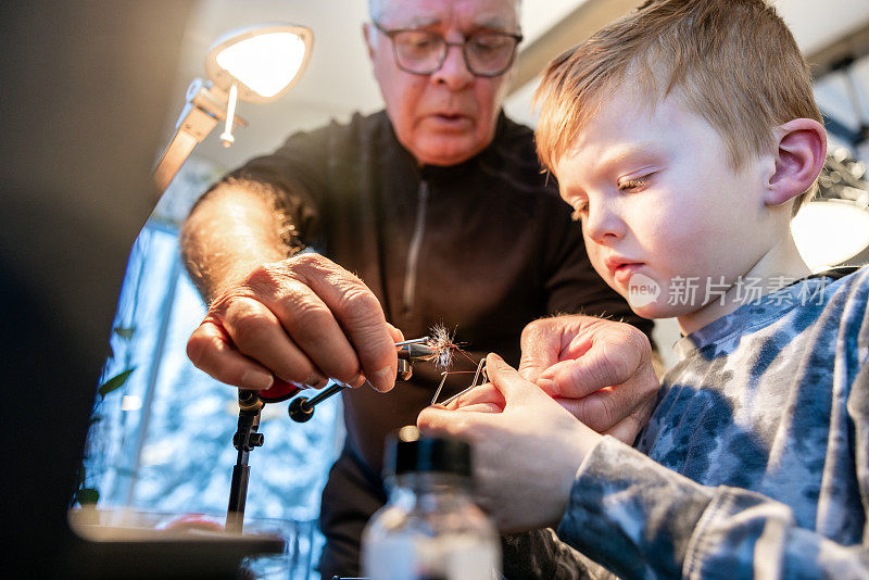 爷爷在家教他的孙子如何让钓鱼飞蝇