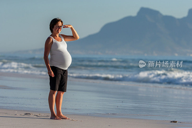 孕妇赤脚站在沙滩上看风景