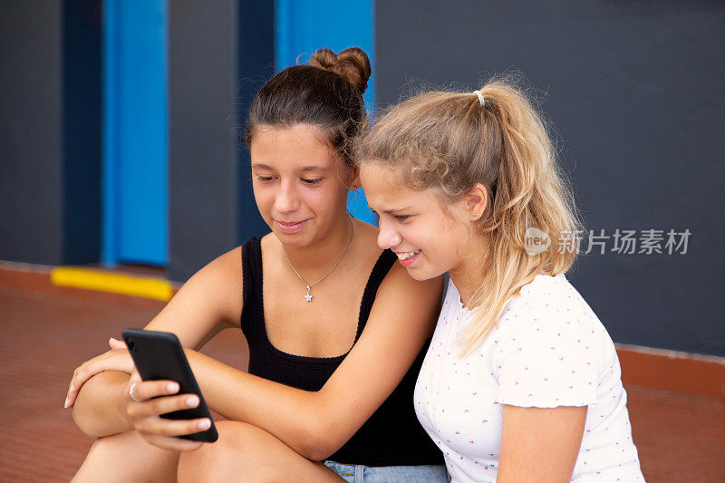 两个十几岁的女孩在看手机视频