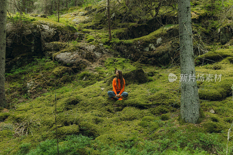 在森林里的苔藓上休息的女人在思考瑞典的自然