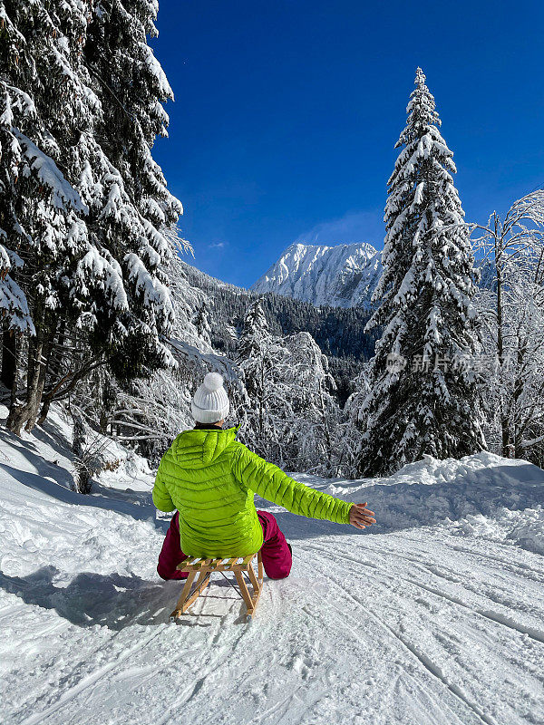 纵览:在阿尔卑斯山滑雪的女游客兴奋地张开她的手臂。